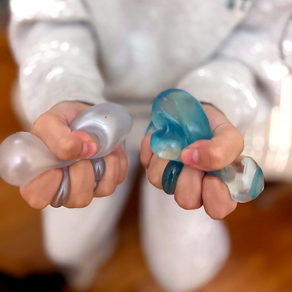 Two Squishlotte Original squishies in open hands showing the soft, mouldable texture
